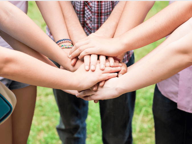 group of teens hand coming together