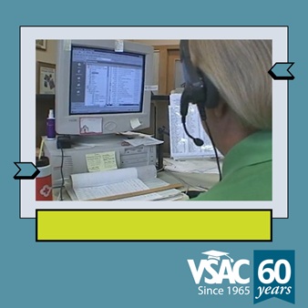 A woman sits at a computer workstation from the early 2000s.