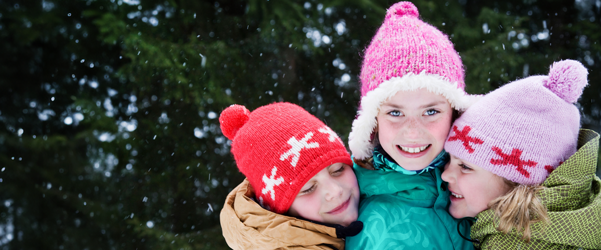 three siblings in winter clothing