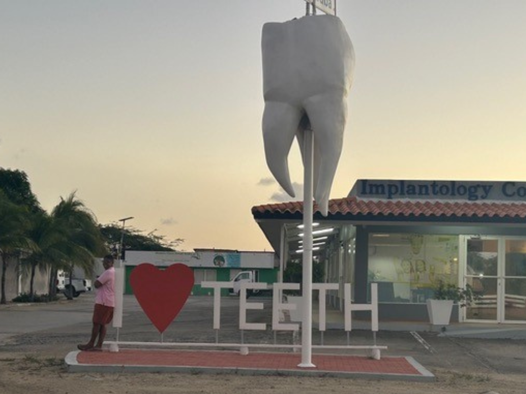student standing next to a sign that read I love teeth