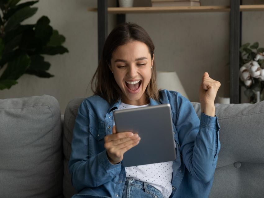 Young woman excited looking at a tablet