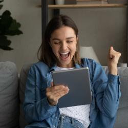 Young woman excited looking at a tablet