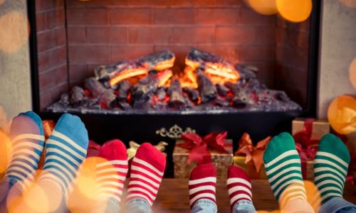Family with different color striped socks with feet in front of a fireplace